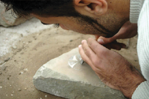Mann bei der Herstellung eines Muschelsteins